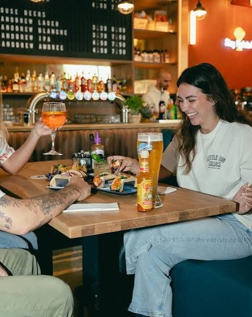 Des clients attablés autour de tacos et de bières, au comptoir du restaurant.